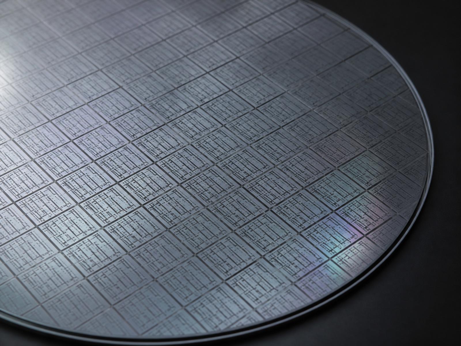Silicon wafer showing a grid of ASIC die under soft directional light