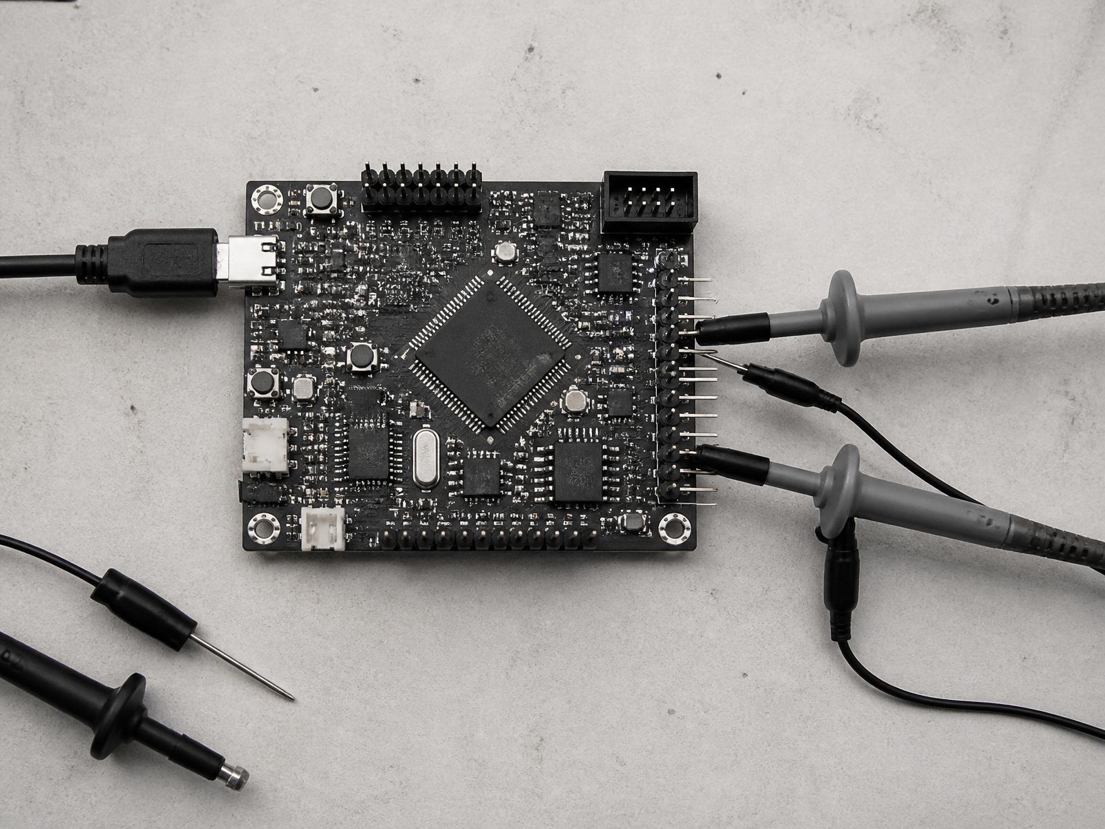 ARM microcontroller development board with oscilloscope probes attached for signal capture